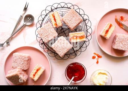 Australian Pink Lamington Small Square Cakes mit Erdbeermarmelade und Kokosnuss. Stockfoto