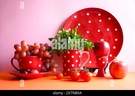 Rotes Obst und Gemüse mit rotem Polka Dot-Geschirr, Farbblockade-Ästhetik. Rote Lebensmittel enthalten starke gesunde Antioxidantien, Lycopin, Anthocyan Stockfoto