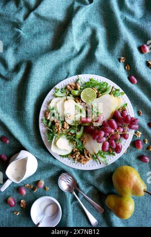 Salat im Waldorfstil mit Birnen, Walnüssen, Sellerie, Trauben und Baby-Raketenblättern. Negativer Kopierbereich. Stockfoto