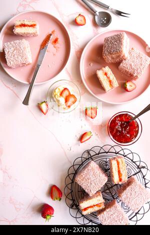 Australian Pink Lamington Small Square Cakes mit Erdbeermarmelade und Kokosnuss. Stockfoto