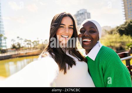 Selfie-Foto von zwei jungen Freundinnen, die glücklich und sorglos in einem Stadtpark lächeln, Konzept der Vielfalt und des modernen Lebensstils, Kopierraum für Text Stockfoto