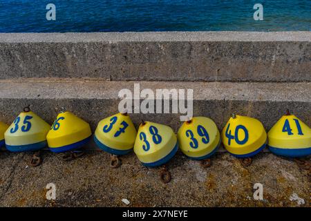 Gewinnung der Lotterie Bunte Bojen mit Zahlen und Buchstaben an der Küste Kroatien Jadran Stockfoto