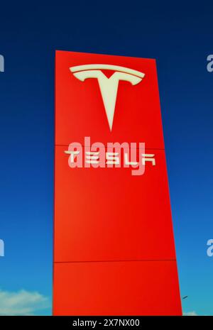 Tesla-Logo. Tesla, Inc. – Bis 1. Februar 2017 Tesla Motors, ist ein börsennotierter US-amerikanischer Autohersteller mit Sitz in Austin, der neben Elektroautos auch Batteriespeicher, Batterie-Speicherkraftwerke und Photovoltaikanlagen produziert. Gegründet wurde das Unternehmen im Jahr 2003 von Martin Eberhard und Marc Tarpenning, die 2008 ausschieden. Im Frühjahr 2004 steigt Risikokapital-Investoren ein, Elon Musk wurde Aufsichtsratsvorsitzender und ist seitdem prägende Figur von Tesla. Das Unternehmen unterhält Stand Oktober 2023 mehrere Produktionsstandorte in den Vereinigten Staaten, hinz Stockfoto