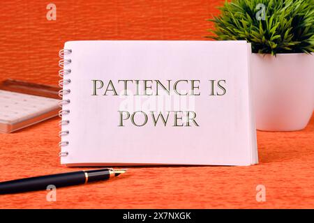 Persönliches Entwicklungskonzept. Words PATIENCE IST EIN weißes Notebook mit orangefarbenem Hintergrund Stockfoto