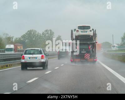 Piacenza, Italien - 22. April 2024 Eine Autobahnszene unter bewölktem Himmel mit Autos und Lastwagen mit Straßenschildern und einem regnerischen Tag auf Motorwa Stockfoto