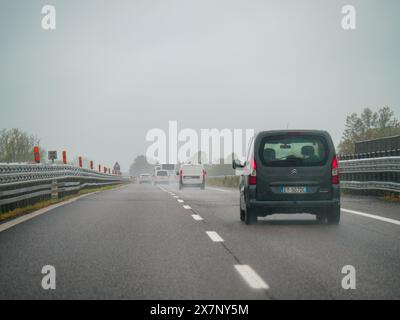 Piacenza, Italien - 22. April 2024 Eine Autobahnszene unter bewölktem Himmel mit Autos und Lastwagen mit Straßenschildern und einem regnerischen Tag auf Motorwa Stockfoto