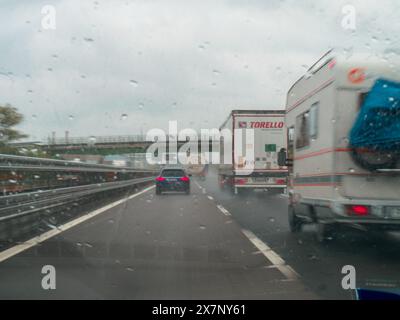 Piacenza, Italien - 22. April 2024 Eine Autobahnszene unter bewölktem Himmel mit Autos und Lastwagen mit Straßenschildern und einem regnerischen Tag auf Motorwa Stockfoto