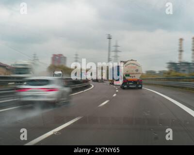 Piacenza, Italien - 22. April 2024 Eine Autobahnszene unter bewölktem Himmel mit Autos und Lastwagen mit Straßenschildern und einem regnerischen Tag auf Motorwa Stockfoto