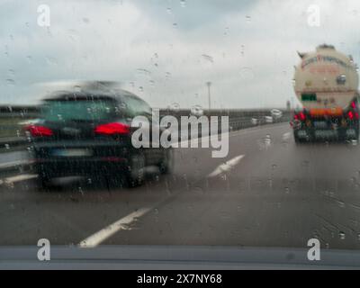 Piacenza, Italien - 22. April 2024 Eine Autobahnszene unter bewölktem Himmel mit Autos und Lastwagen mit Straßenschildern und einem regnerischen Tag auf Motorwa Stockfoto