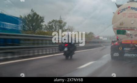 Piacenza, Italien - 22. April 2024 Eine Autobahnszene unter bewölktem Himmel mit Autos und Lastwagen mit Straßenschildern und einem regnerischen Tag auf Motorwa Stockfoto