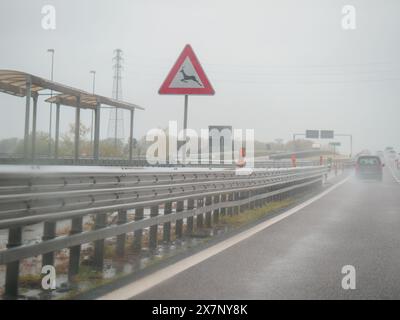 Piacenza, Italien - 22. April 2024 Eine Autobahnszene unter bewölktem Himmel mit Autos und Lastwagen mit Straßenschildern und einem regnerischen Tag auf Motorwa Stockfoto