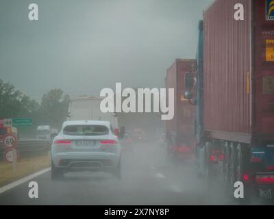 Piacenza, Italien - 22. April 2024 Eine Autobahnszene unter bewölktem Himmel mit Autos und Lastwagen mit Straßenschildern und einem regnerischen Tag auf Motorwa Stockfoto