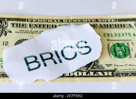 Ein Dollarisierungskonzept mit dem Wort BRICS auf einem US-Dollar-Schein, isoliert in weiß. Stockfoto