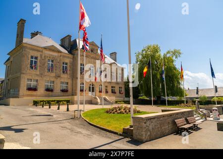 NORMANDIE, FRANKREICH - 1. Juni 2017: Flaggen fliegen vor dem Rathaus in St Mere Eglise, der ersten Stadt, die von amerikanischen Fallschirmjägern auf D-da befreit wurde Stockfoto
