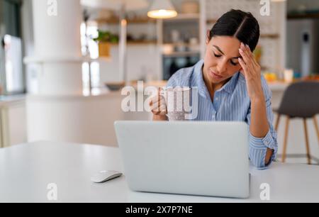 Müde Geschäftsfrau schläfrig und gelangweilt vom Sitzen am Schreibtisch für eine lange Zeit und hat ein Bürosyndrom Stockfoto