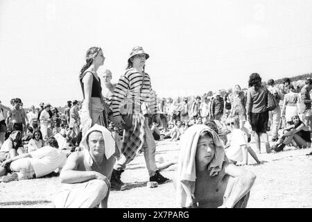 CROWD, HEATWAVE, HANDTUCH AUF KÖPFEN, NME STAGE, GLASTONBURY 95: Festivalbesucher krachen mit Handtüchern auf dem Gras in der extremen Sommer Hitzewelle auf dem zweiten NME Stage Field und Crowd beim Glastonbury Festival, Pilton Farm, Somerset, England, 24. Juni 1995. 1995 feierte das Festival sein 25-jähriges Bestehen. Viele Menschen hatten an dem besonders heißen Wochenende Probleme mit dem Hitzschlag. Foto: ROB WATKINS Stockfoto