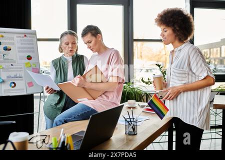 Eine Gruppe fleißiger, vielfältiger weiblicher Profis versammelte sich an einem Tisch in einer Büroumgebung. Stockfoto