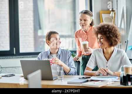 Verschiedene Gruppen von weiblichen Fachleuten, die an einem Meeting rund um einen Laptop teilnahmen. Stockfoto