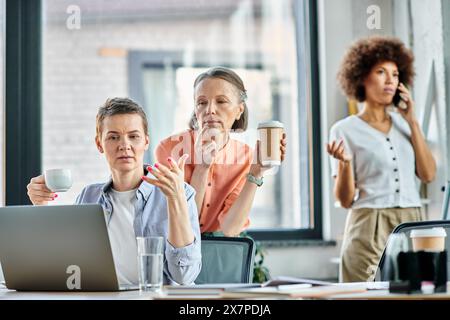 Verschiedene Gruppen von Fachleuten, die an einem gemeinsamen Meeting mit einem Laptop an einem Tisch teilnahmen. Stockfoto