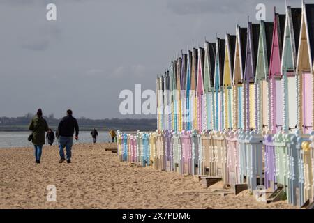 Hübsche bunte Strandhütten am West Mersea Beach in Essex UK. Stockfoto