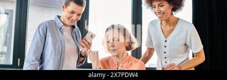 Verschiedene Gruppen hart arbeitender Geschäftsfrauen versammelten sich um einen Laptop in einer gemeinsamen Büroumgebung. Stockfoto
