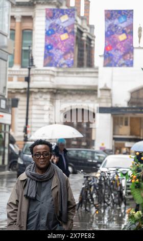 Cork Street, London, Großbritannien. Mai 2024. Sir John Akomfrah (im Bild) mit seinem neuen Werk The Secret Life of Memorable Things (2024), das in der Cork Street für das London Gallery Weekend enthüllt wird, und besteht aus fünf Zeilen doppelseitiger Banner auf der Cork Street, mit drei Bannern pro Zeile und insgesamt 30 Einzelkunstwerken, wodurch eine Ausstellung von Norden nach Süden und eine weitere von Süden nach Norden entsteht. Es folgt auf die Präsentation des Künstlers auf der Biennale in Venedig, Hearing All Night to the Rain, die vom British Council für den British Pavilion in Auftrag gegeben wurde. C Stockfoto