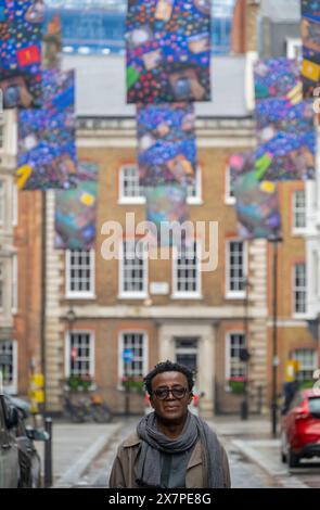 Cork Street, London, Großbritannien. Mai 2024. Sir John Akomfrah (im Bild) mit seinem neuen Werk The Secret Life of Memorable Things (2024), das in der Cork Street für das London Gallery Weekend enthüllt wird, und besteht aus fünf Zeilen doppelseitiger Banner auf der Cork Street, mit drei Bannern pro Zeile und insgesamt 30 Einzelkunstwerken, wodurch eine Ausstellung von Norden nach Süden und eine weitere von Süden nach Norden entsteht. Es folgt auf die Präsentation des Künstlers auf der Biennale in Venedig, Hearing All Night to the Rain, die vom British Council für den British Pavilion in Auftrag gegeben wurde. C Stockfoto