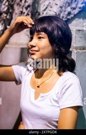 Ein hübsches junges philippinisches Mädchen steht vor der Kirche Santo Nino de Tondo im Tondo District, Manila, den Philippinen. Stockfoto