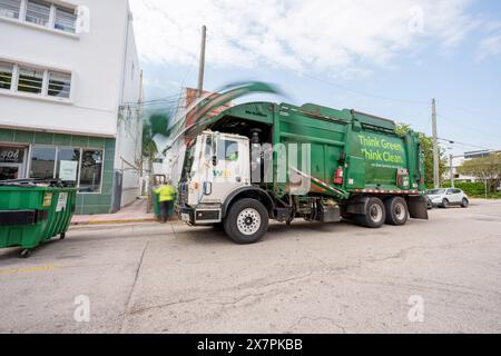 Miami Beach, FL, USA - 20. Mai 2024: WM-Müllwagen entsorgt einen Müllcontainer. Lange Belichtung, die die Bewegung des Krans verschwimmt Stockfoto