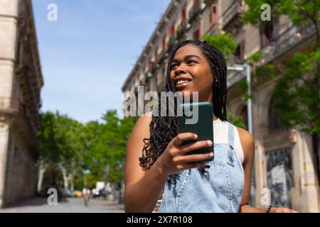 Die junge Frau genießt einen Sommertag mit Freunden in Barcelona und nimmt Momente auf ihrem Smartphone auf Stockfoto