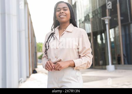 Eine fröhliche junge Frau lächelt hell auf einer sonnigen Straße Barcelonas und verkörpert den lebhaften Geist des Sommers mit Freunden Stockfoto