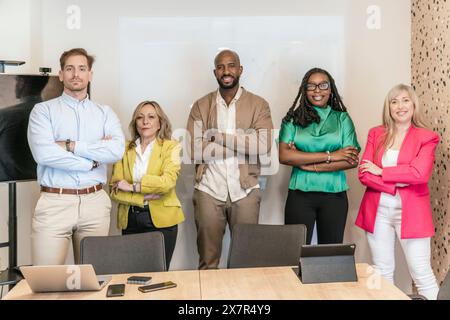 Ein vielseitiges Team von Fachleuten steht selbstbewusst in einem Coworking-Raum und repräsentiert Zusammenarbeit und Einheit am Arbeitsplatz Stockfoto
