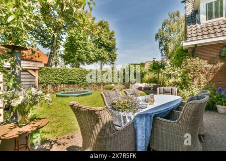Ein gemütlicher Garten im Hinterhof mit einem Esstisch, üppigem Grün und einer ruhigen Atmosphäre am Molenveenweg Stockfoto