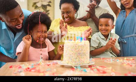 Mehrgenerationenfamilie feiert den Geburtstag der Enkelin zu Hause mit Kuchen und Party Stockfoto