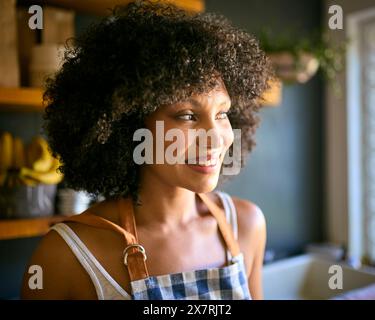 Porträt Einer Frau In Regalen, Die In Einem Lebensmittelgeschäft Mit Schürze Arbeiten Stockfoto