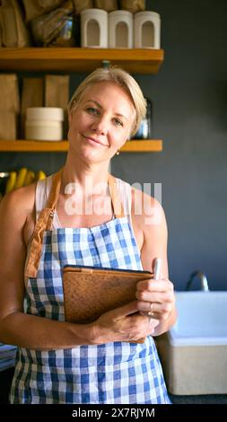Porträt Einer Reiferen Frau, Die In Einem Nachhaltigen Kunststoff-Free-Store Arbeitet, Prüft Den Bestand Mit Einem Digitalen Tablet Stockfoto