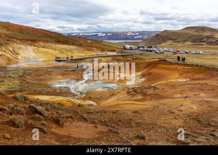 Seltun Geothermie-Gebiet in Krysuvik mit dampfenden heißen Quellen, gelben und orangen Schwefelhügeln, Menschen, die auf Boardstegen spazieren gehen, Island Stockfoto