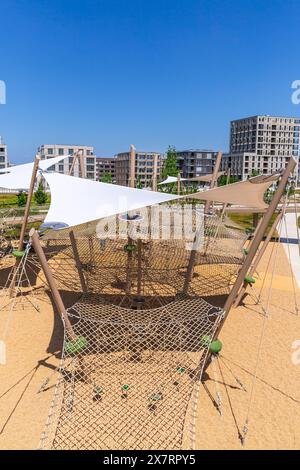 Großer öffentlicher Stadtspielplatz mit Rutschen und Klettergerüst, Panorama des modernen Stadtgebietes Stockfoto