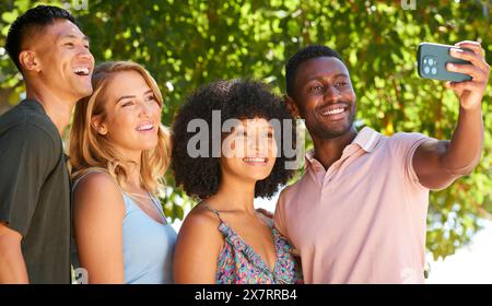 Multi-Racial-Paar Mit Freunden Auf Dem Land, Die Gruppen-Selfie Auf Dem Handy Machen Stockfoto