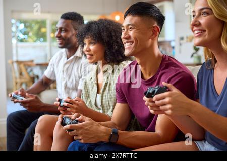 Eine Gruppe Aufgeregter Multi-Racial-Freunde, Die Auf Sofa Sitzen Und Gemeinsam Computerspiele Spielen Stockfoto