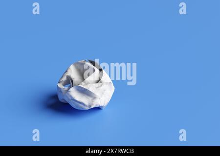 Weiße zerknitterte Papierkugel auf blauem Hintergrund. Illustration des Konzepts der Frustration, des Scheiterns, der Verwirrung, der aufgeblasenen Projekte, der nutzlosen Ideen Stockfoto