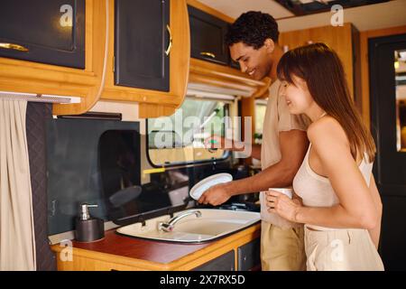 Ein Mann und eine Frau stehen in einer Küche am Waschbecken und teilen einen friedlichen Moment der Zweisamkeit. Stockfoto