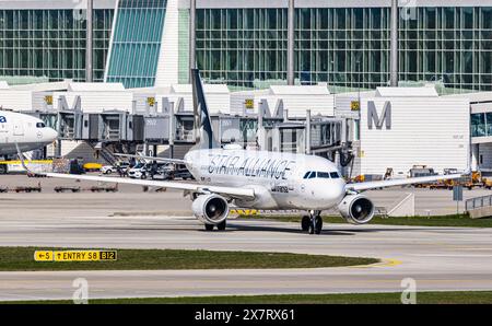 München, 6. April 2024: Ein Lufthansa Airbus A320-214 fährt mit dem Taxi zur Start- und Landebahn am Flughafen München. Das Flugzeug hat eine Star Alliance-Lackierung. (Foto von und Stockfoto