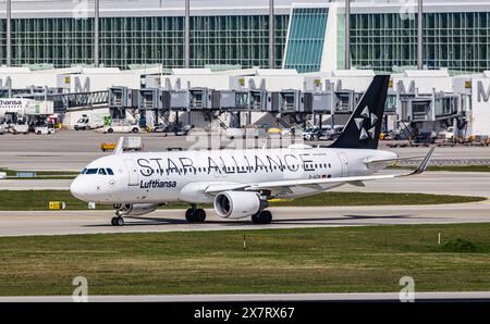 München, 6. April 2024: Ein Lufthansa Airbus A320-214 fährt mit dem Taxi zur Start- und Landebahn am Flughafen München. Das Flugzeug hat eine Star Alliance-Lackierung. (Foto von und Stockfoto