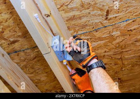 Elektriker, der Deckeneinbauleuchten mit Anschlusskasten in einem neuen Zuhause installiert Stockfoto