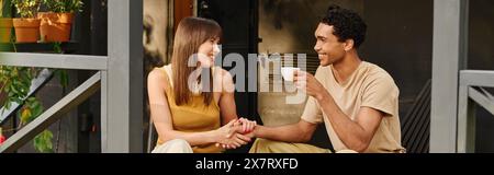 Ein Mann und eine Frau sitzen friedlich auf einer Veranda, genießen sich gegenseitig Gesellschaft und die ruhige Umgebung. Stockfoto