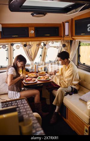 Ein interrassisches Paar sitzt zusammen in einem Bus und teilt einen ruhigen Moment, während er die Welt draußen vorbeizieht. Stockfoto