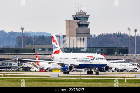 Ein British Airways Airbus A319-131 fährt mit dem Taxi zur Start- und Landebahn am Flughafen Zürich. Im Hintergrund befindet sich der Leitturm des Flughafens Zürich. Registrierung der Ai Stockfoto