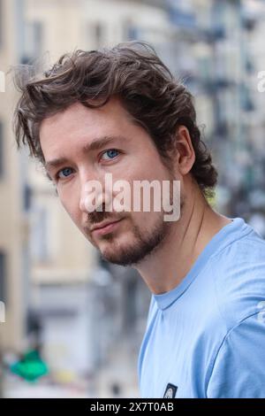 Hübscher junger Mann mit blauen Augen und lockigen, welligen Haaren Stockfoto