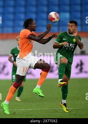 Qingdao, Chinas Provinz Shandong. Mai 2024. Li Ke (R) aus Peking Guoan streitet mit Martin Boakye aus Qingdao Hainiu während des 13. Runde Spiels zwischen Qingdao Hainiu und Peking Guoan in der Chinesischen Super League 2024 in Qingdao, ostchinesischer Provinz Shandong, am 21. Mai 2024. Quelle: Li Ziheng/Xinhua/Alamy Live News Stockfoto